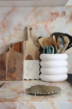 a marble counter top with various kitchen utensils