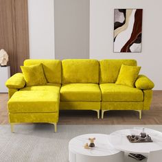 a living room with a yellow couch and coffee table on the floor in front of it