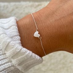 ✧ P E A R L ~ H E A R T ~ B R A C E L E T ✧ ✧ Pearl Heart feature charm and tiny 925 sterling silver chain.  ✧ Clasp closure, no extender. Can only be worn at length chosen.  ✧ Model wears size S.  ✧ All hearts will vary very slightly as each is individually cut and unique.  ✧ S I Z E ~ G U I D E ~ Select your choice from the drop down list;  XXS - 5", XS - 6", S - 7", M - 8", L -9" ✧ S H I P P I N G ✧ Please note, 'standard shipping' does not include tracking. Only 'tracked' or 'express' orders Pearl Christmas, Heart Bracelets, Bracelet Heart, Pearl Heart, Bracelet Dainty, 925 Silver Bracelet, T B, Christmas Gift For Her, 925 Sterling Silver Chain