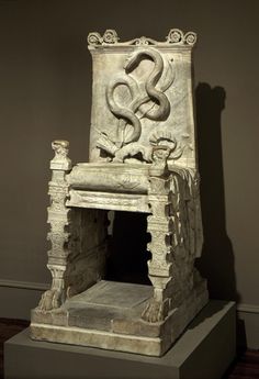 an old chair sitting on display in a museum