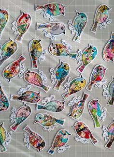 many colorful birds are shown on a sheet of paper