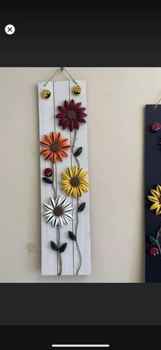 two wooden wall hangings with flowers on them