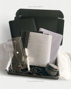 an assortment of office supplies sitting on top of each other in a black box with white writing