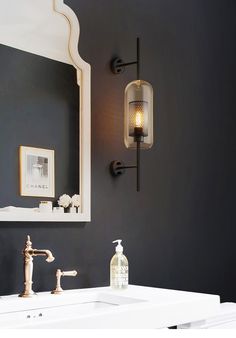 a bathroom with a sink, mirror and soap dispenser