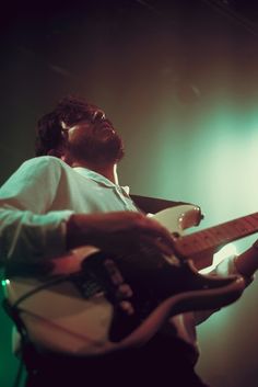 a man is playing an electric guitar on stage