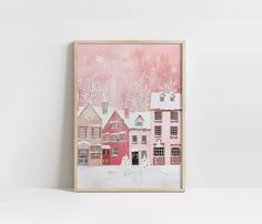 a pink house with snow on the roof and trees in the background is framed by a wooden frame