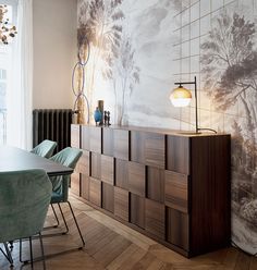 a dining room table and chairs in front of a wall mural