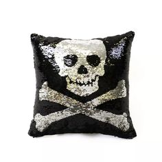 a sequin skull and crossbone pillow on a white background with black sequins