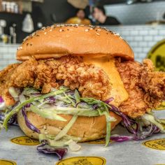 a fried chicken sandwich sitting on top of a table