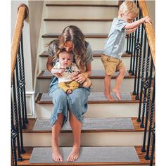 two children are sitting on the stairs with their mom