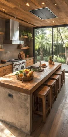 a kitchen with wooden floors and an island in the middle, surrounded by glass doors