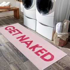 a pink door mat that says get naked on it in front of washer and dryer