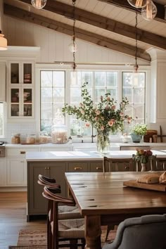 a kitchen filled with lots of counter space and wooden floors next to a dining room table