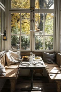 a table and benches in front of large windows