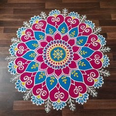 a colorful flower design painted on the floor in front of a wooden floor with wood planks