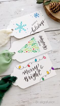 three christmas gift tags with the words merry and bright on them, sitting next to some pine cones