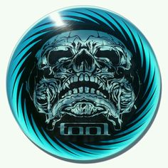 a blue and black frisbee with an image of a skull in the center