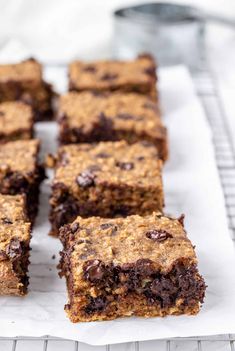 chocolate chip cookie bars sitting on top of a white paper towel next to a cooling rack