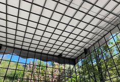 the inside of a caged area with trees in the background