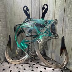 a glass fish sculpture sitting on top of a metal shelf next to a wooden wall