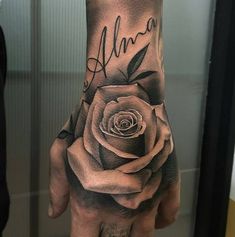 a woman's hand with a rose tattooed on it and the word ann written in cursive writing