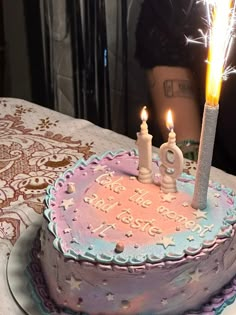 a birthday cake with two lit candles on it