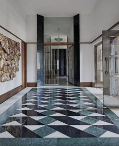 a hallway with marble floors and paintings on the walls