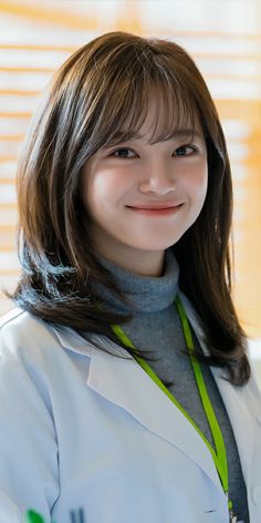 a woman wearing a white lab coat and smiling