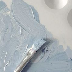 a paintbrush is sitting on top of some blue paint