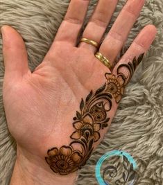 a hand with henna tattoos on it