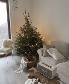 a living room with a christmas tree in the corner and an animal rug on the floor