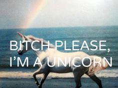 a white horse running on the beach near the ocean with a rainbow in the background