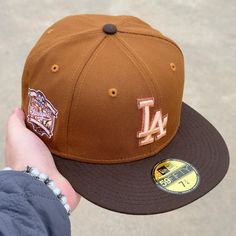 a baseball cap with the los angeles dodgers embroidered on it is held by a person's hand