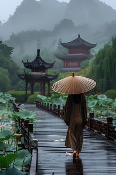 a woman with an umbrella walking down a rain soaked walkway in front of pagodas