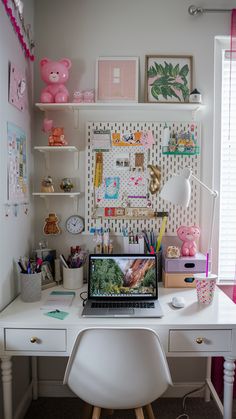 a laptop computer sitting on top of a white desk next to a pink teddy bear