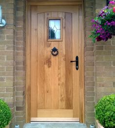 a wooden front door with two planters on either side