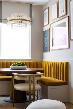 a yellow banquet table and bench in a room with pictures on the wall above it