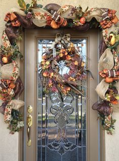 the front door is decorated with fall wreaths