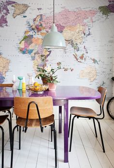 a purple table with chairs around it in front of a map on the wall behind it