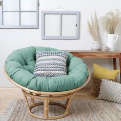 a chair with a pillow on top of it in front of a table and pictures