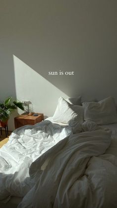 an unmade bed with the words sun is out on it's back wall