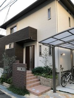 a bicycle is parked in front of a house on the side of the street with stairs leading up to it