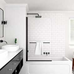 a white bathroom with black and white flooring, two sinks and a bathtub