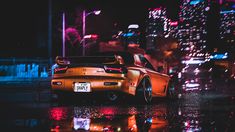 an orange sports car parked in the rain at night with city lights reflected on the wet pavement