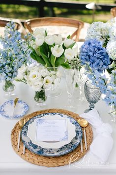 a table set with blue and white flowers