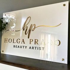 a glass sign that says holica prato beauty artist on the side of a wall