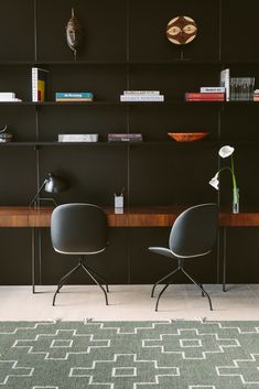 two chairs sitting in front of a book shelf