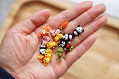 small toy animals are placed in the palm of someone's hand