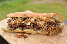 a close up of a sandwich on a cutting board with the words get this recipe above it