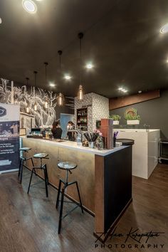 the interior of a coffee shop with stools and bar counter area in front of it